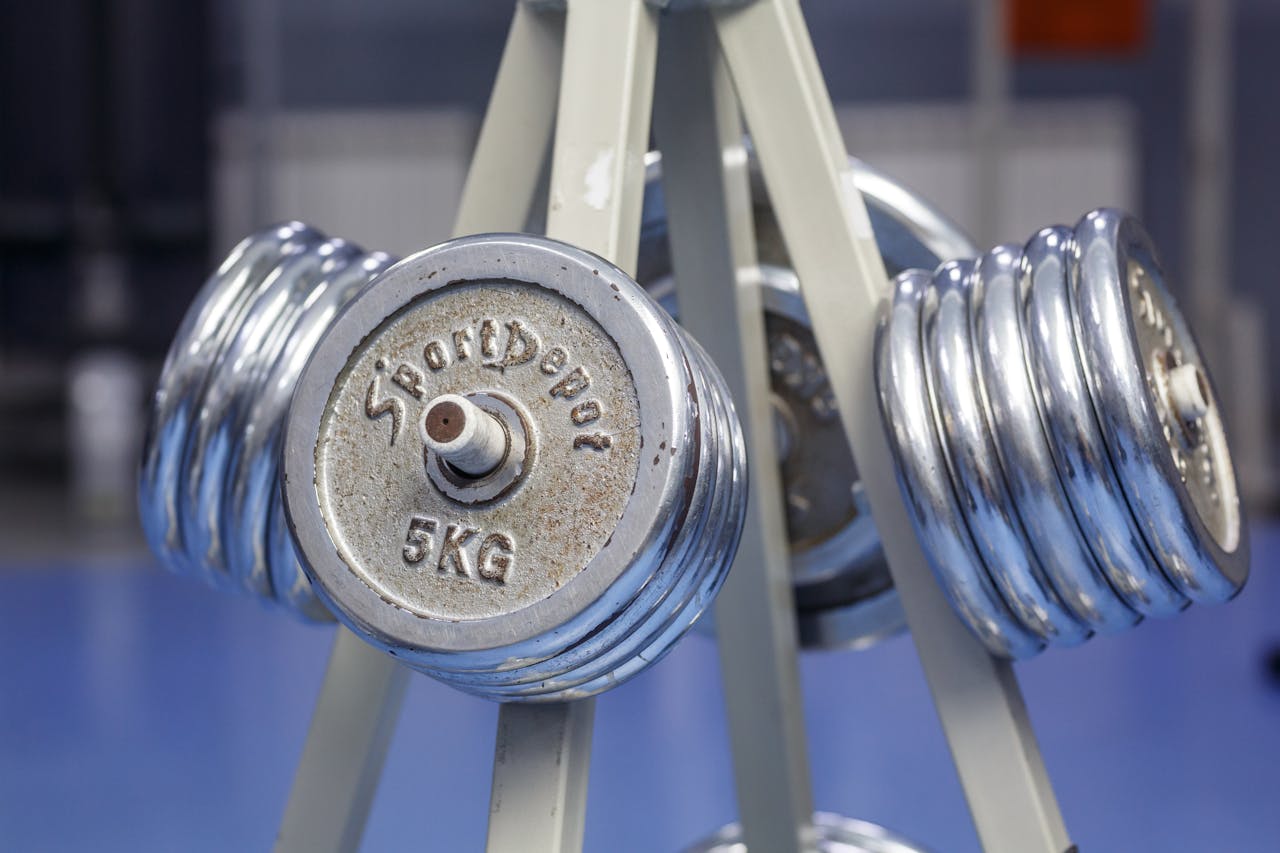 About Close-up of chrome dumbbells on a gym rack displaying 5kg weights.